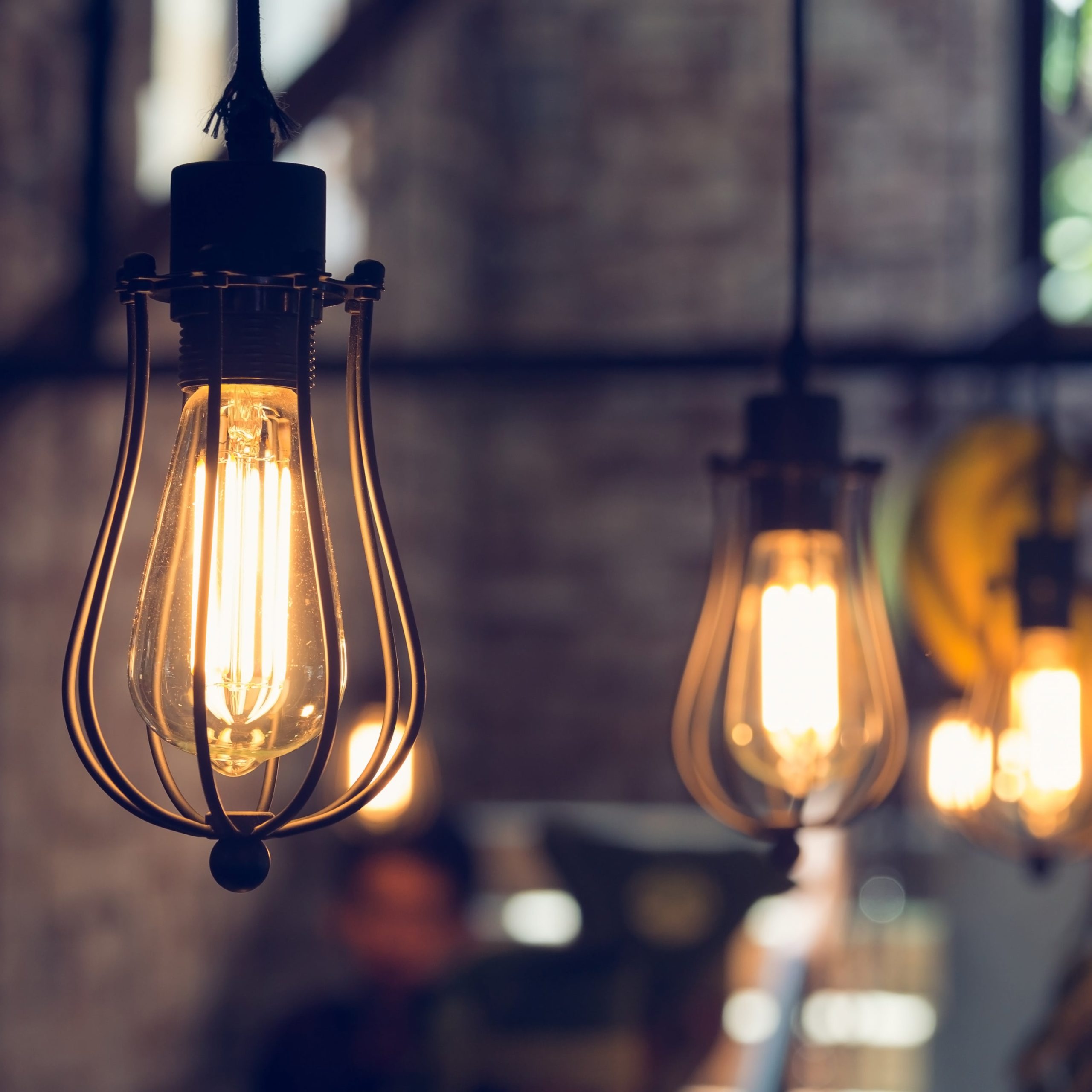 industrial lighting fixtures hanging in a brick kitchen covered by a premium home warranty plan